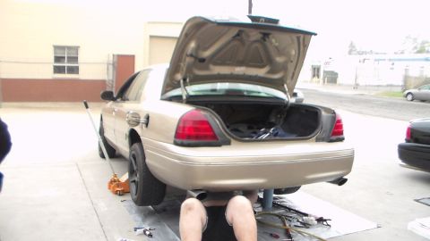 2003 Ford Crown Victoria - Photo of a gold Ford Crown Victoria with its trunk open being worked on outdoors, not a technical document.