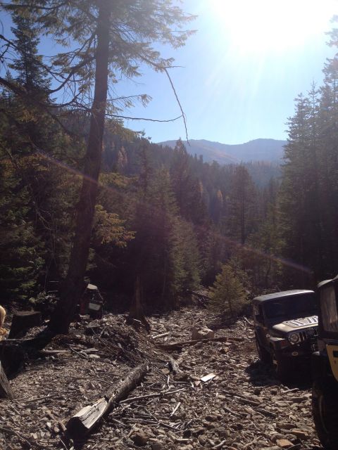 2005 Jeep Wrangler - Two Jeep Wranglers are parked on a rocky, wooded trail with a bright sun shining through the trees.