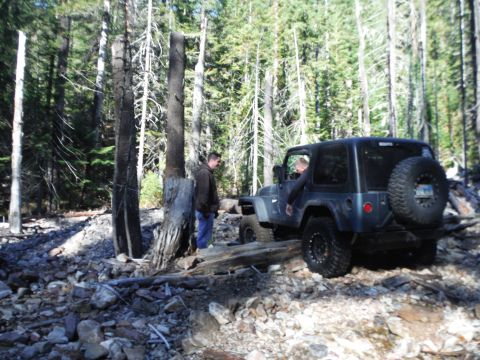 2005 Jeep Wrangler - 2005 Jeep Wrangler navigating a challenging rocky path in a wooded area.