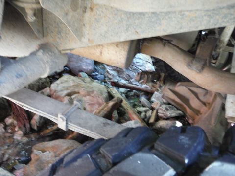 2005 Jeep Wrangler - Undercarriage components including leaf springs and exhaust pipe are visible amidst debris.