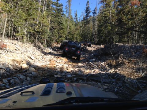 2005 Jeep Wrangler - Jeeps tackling a challenging off-road trail in a forested mountain area.