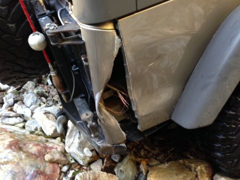 2005 Jeep Wrangler - The front fender and bumper of this vehicle are significantly damaged, revealing exposed wiring.