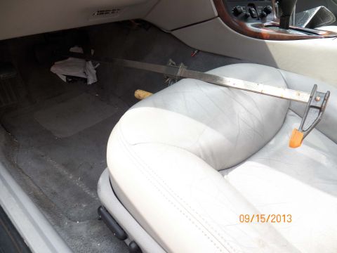1998 Lincoln Mark VIII - A metal clamp is placed on the passenger seat of a car's interior.