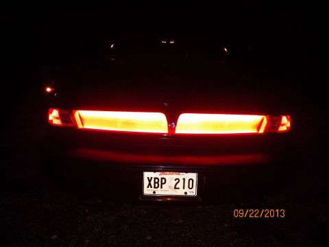 1998 Lincoln Mark VIII - The rear of a car is shown at night, with its brake lights illuminated.
