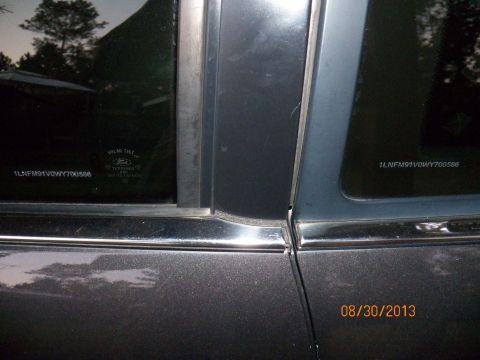 1998 Lincoln Mark VIII - Close-up of a car's side window and door frame, revealing VIN details and a timestamp.