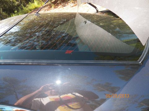 1998 Lincoln Mark VIII - The rear window seal on a 1998 Lincoln Mark VIII shows a small red diamond sticker.