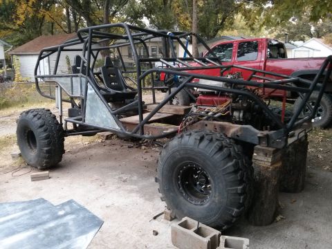 1986 Ford Bronco - A custom-built off-road buggy is under construction, with a red pickup truck visible in the background.