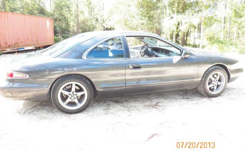 1998 Lincoln Mark VIII - Side profile of a 1998 Lincoln Mark VIII coupe parked outdoors.