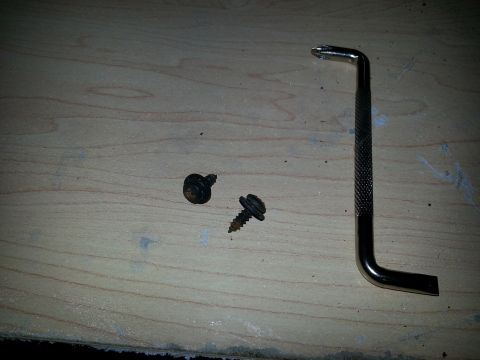 1994 Ford Bronco - A hex wrench and two screws are laid out on a wooden surface.