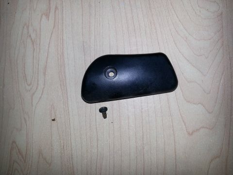 1994 Ford Bronco - A black plastic trim piece and a screw are shown on a light wood-grain surface.