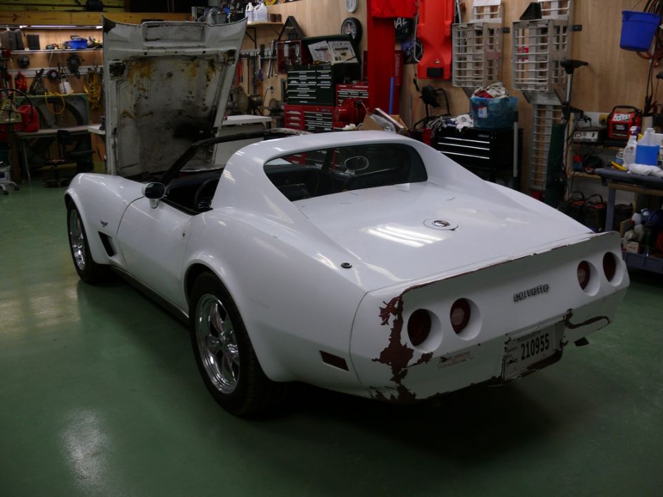 1976 Chevrolet Corvette with hood open, showing rust on rear bumper