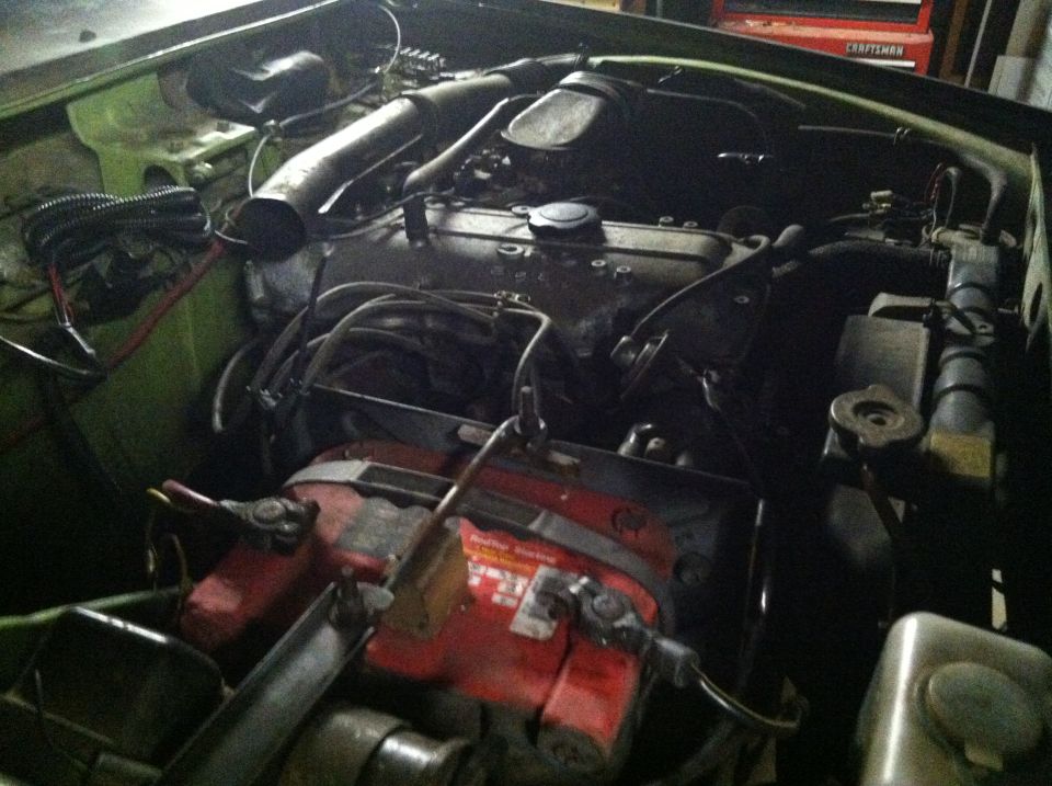Engine bay with red battery and black engine components
