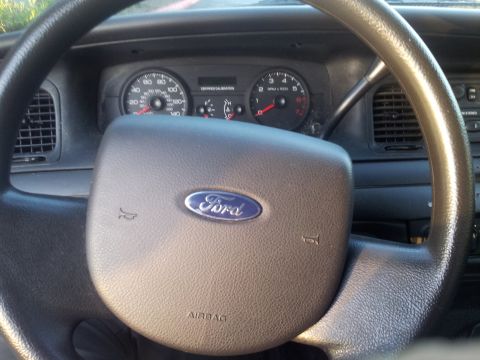 2006 Ford Crown Victoria - The dashboard and steering wheel of a 2006 Ford Crown Victoria are visible in this interior shot.