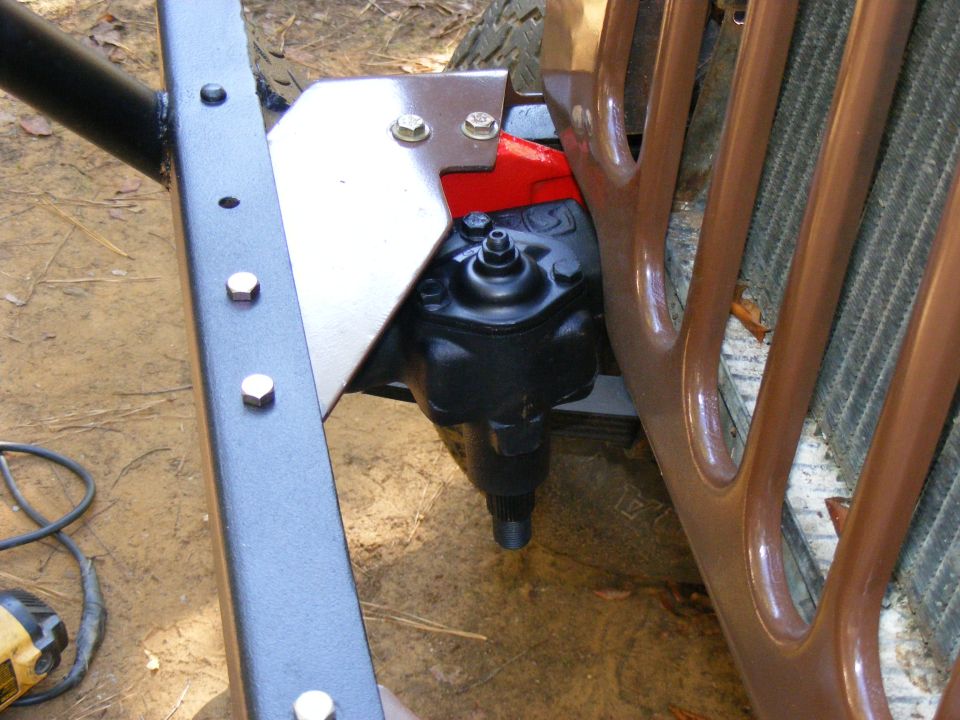Close-up of steering box and part of a grille on a vehicle frame