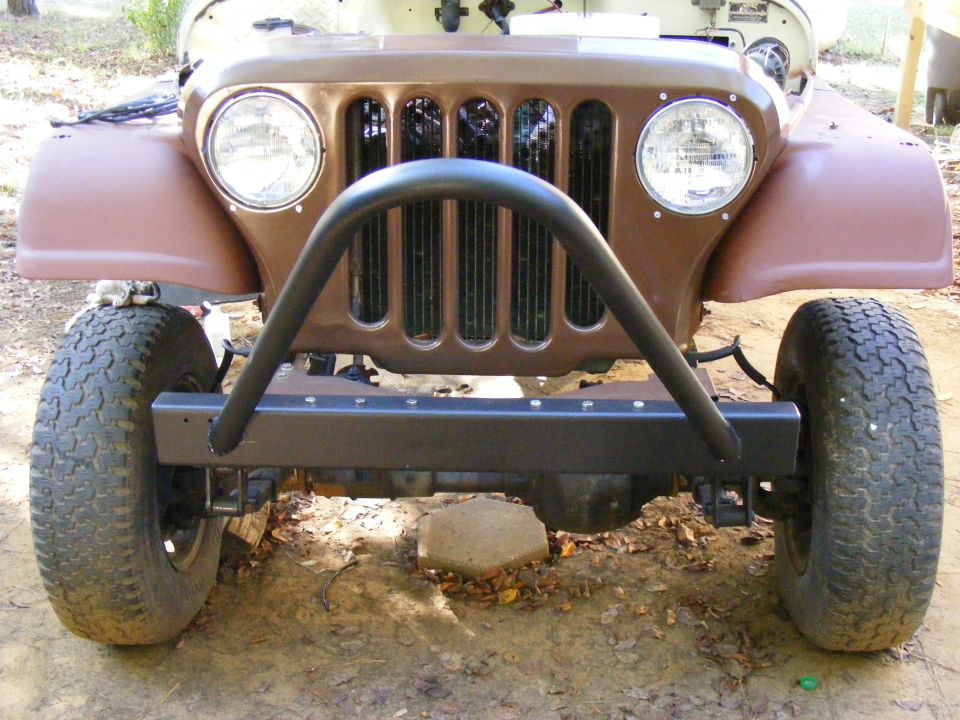 Brown Jeep CJ-5 front end with a black roll bar and aftermarket bumper