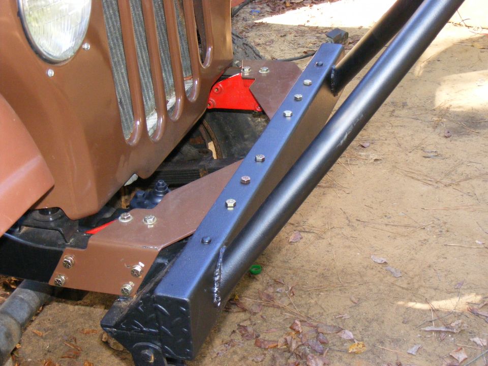 Brown vehicle front bumper and grille with custom roll cage attachment