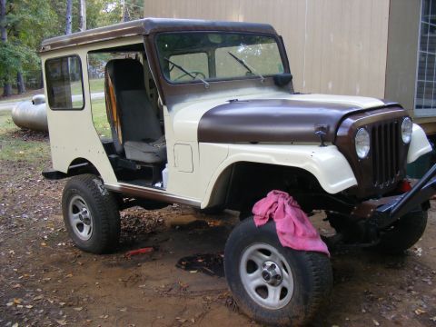 Jeep CJ-5 with removable hardtop, undergoing restoration. Beige and brown paint scheme