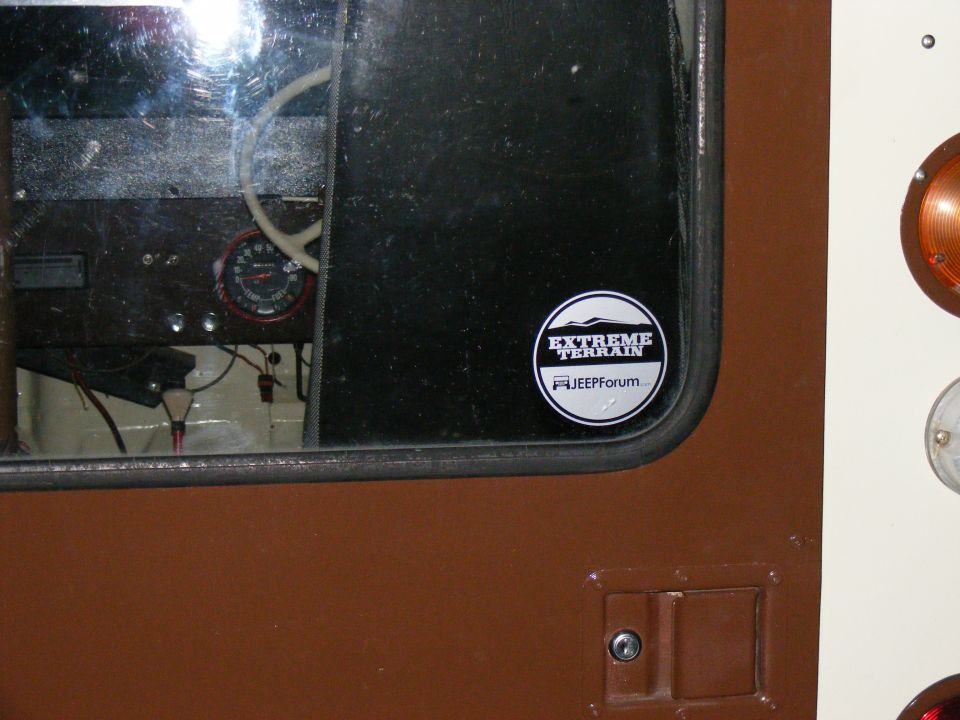 Interior view of a vehicle showing a gauge and an Extreme Terrain/JeepForum sticker