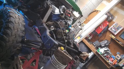 1967 Ford F-250 - A vehicle's engine and chassis are visible, supported by jack stands in a cluttered garage setting.