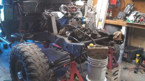 1967 Ford F-250 - A truck chassis is undergoing repairs or modifications in a workshop, with its engine and suspension components visible.