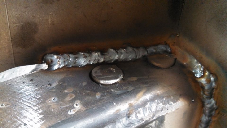 Close-up of a metal joint with visible welds and some circular metal pieces