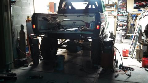 1967 Ford F-250 - Modified pickup truck with custom rear bumper and roll bar is seen in a workshop environment.