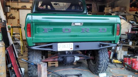 1967 Ford F-250 - Rear view of a green 1967 Ford F-250 pickup truck with a custom bumper and off-road tires.