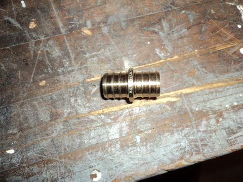 2004 Mercury Grand Marquis - A brass fitting with ribbed texture is shown on a wooden surface. Text is visible on the fitting.