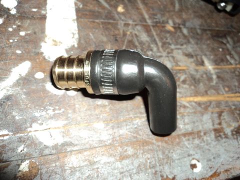 2004 Mercury Grand Marquis - A close-up of a metal and rubber fitting, likely a plumbing or automotive part, resting on a textured wooden surface.
