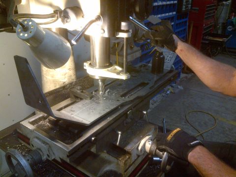 1985 Jeep CJ7 - A close-up view of a milling machine in operation, with a worker's hands guiding the process.