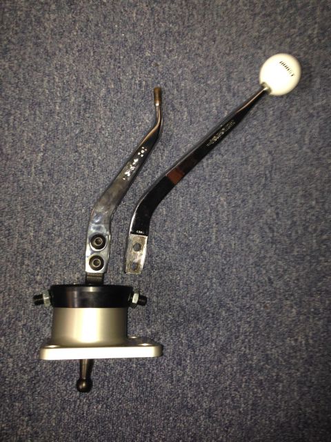 2004 Ford Crown Victoria - A close-up view of an aftermarket automotive shifter assembly, including the shift knob and base, is displayed on a textured surface.
