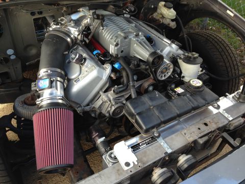 2004 Ford Crown Victoria - Engine bay a prominent supercharger, aftermarket air intake, and aluminum radiator, suggesting a performance modification.