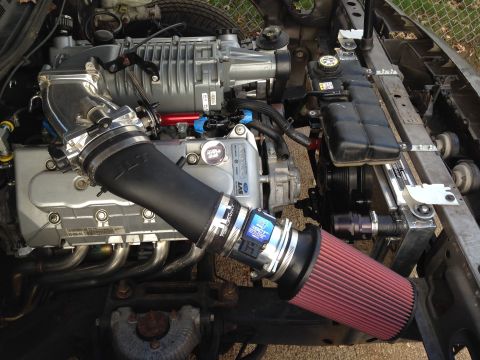 2004 Ford Crown Victoria - Close-up of a supercharged V8 engine, an SVT logo and aftermarket intake system.