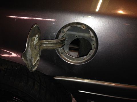 2004 Ford Crown Victoria - The fuel filler door is open, revealing the mechanism underneath.