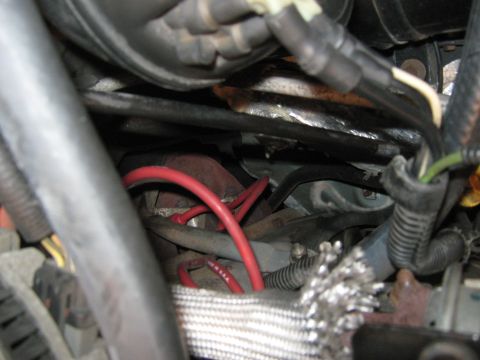 1996 Ford Bronco - Close-up view of engine bay components, including red spark plug wires and electrical wiring.