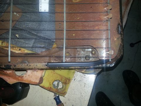 1994 Ford Bronco - Close-up of a worn seat frame, showing springs, rusted metal, and yellow foam. A label with text is partially visible.