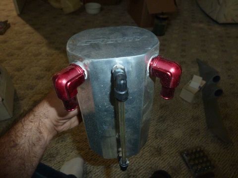 2007 Subaru Impreza - An aluminum oil catch can with red fittings is shown from a top-down perspective.