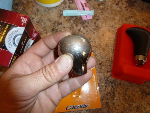 2007 Subaru Impreza - A chrome shift knob is held in a hand, with other car parts in the background.