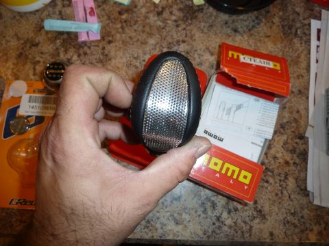 2007 Subaru Impreza - A hand holds a clear reflector part, possibly for a vehicle, with MOMO and CTEAIR packaging visible.