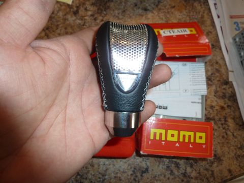 2007 Subaru Impreza - Momo Italy gear shift knob with perforated metal and leather is held in a hand.