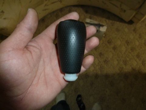 2007 Subaru Impreza - A black textured gear shift knob is held in a person's hand, showing the part in detail.