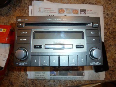 2007 Subaru Impreza - A car stereo unit is shown, likely a replacement part, with various control buttons and a CD slot.