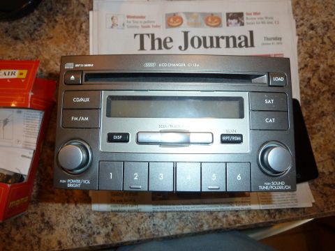 2007 Subaru Impreza - Car stereo unit with CD changer and numbered buttons, lying on a newspaper.