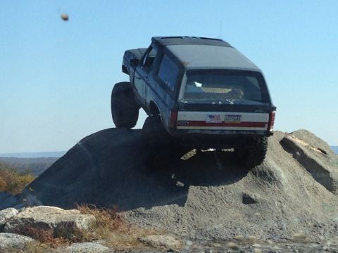 1996 Ford F-150 - This modified Ford Bronco is tackling a rocky incline, its off-road capabilities.