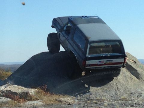 1996 Ford F-150 - This lifted SUV is navigating a challenging rocky terrain, its off-road capabilities.