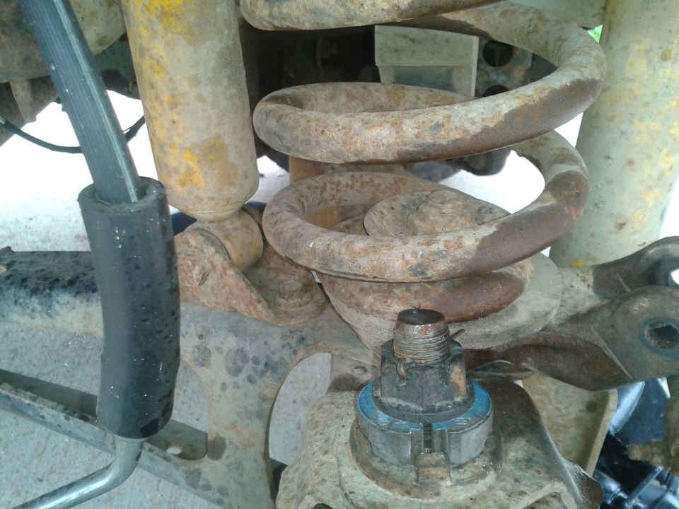 Close-up of rusty suspension coil and shock absorber