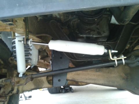 1988 Ford Bronco - The underside of a vehicle displays its suspension and steering systems, with white shock absorbers prominently featured.