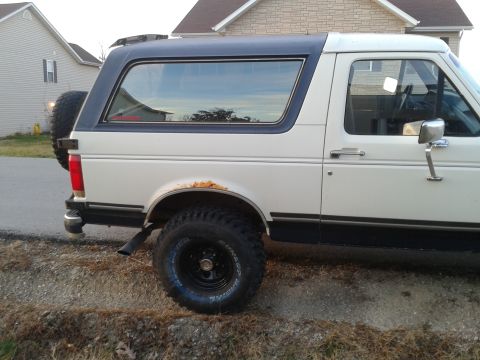 1988 Ford Bronco - This 1988 Ford Bronco is seen from the side, showing its two-tone paint and a spare tire mounted on the back.