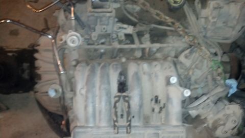 1988 Ford Bronco - Close-up view of a dirty engine, showing the intake manifold and associated components.