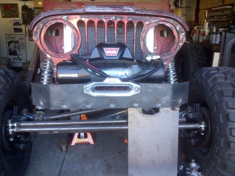 1985 Jeep CJ7 - This Jeep CJ features a prominent winch and a custom-fabricated front bumper, with its grille and headlight housings removed.